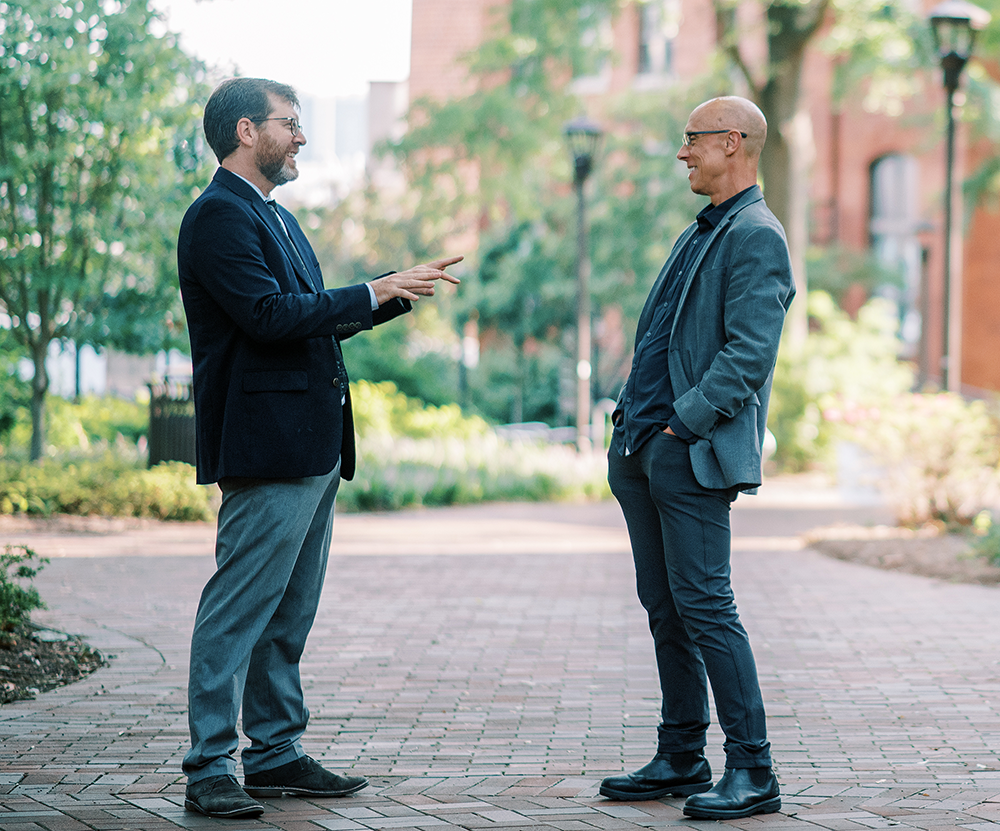 Two white men talking outside a Tech building.