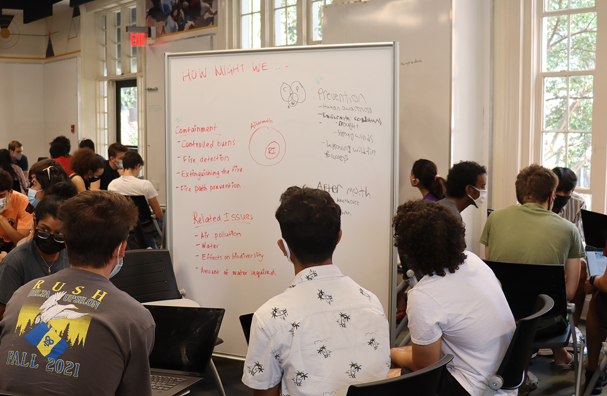 Students in a class in front of a white board.