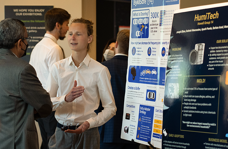 A young male GT student presents his BykeSafe project during a poster event.
